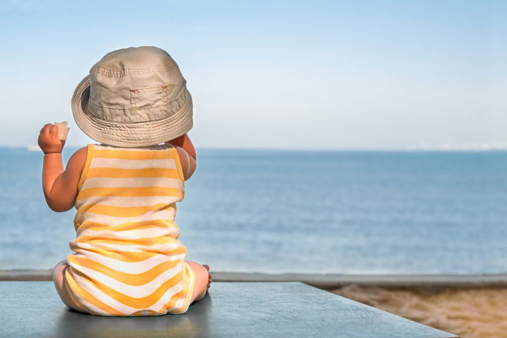 7 bébé à la plage, avec un chapeau